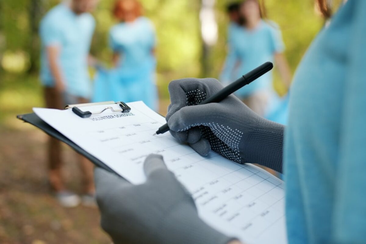Gloved hand filling out a service checklist on a clipboard