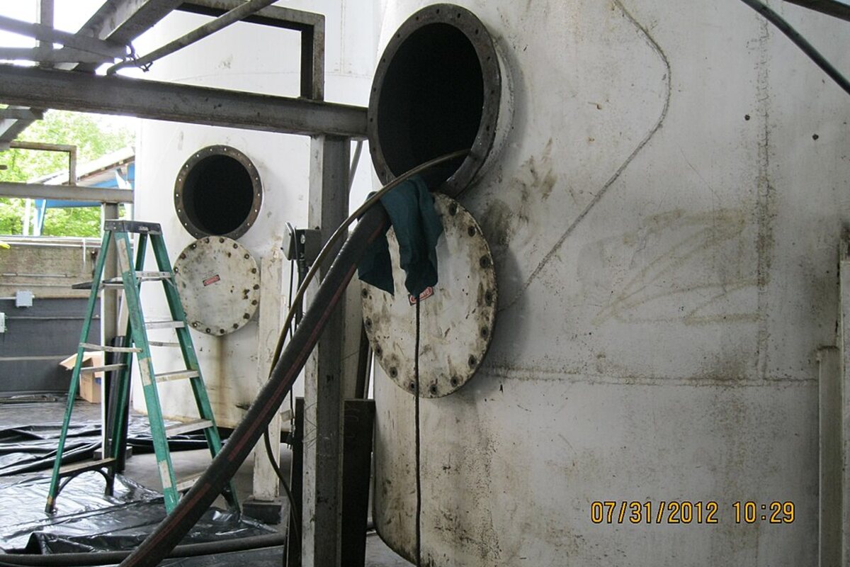 Vacuum hose and cleaning equipment connected to an industrial tank